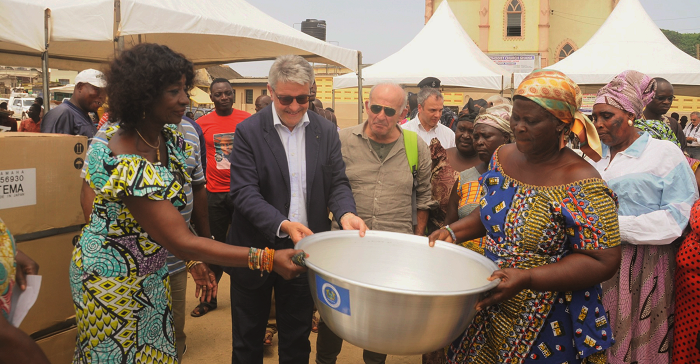 Mr Giovanni Tumbiolo (2nd left), President of Fish Production District of Mazara Del Vallo of Italy, being assisted by Ms Sherry Ayittey (left), the Minister of Fisheries and Aquaculture Development, to present bowls to some fishmongers at Apam.